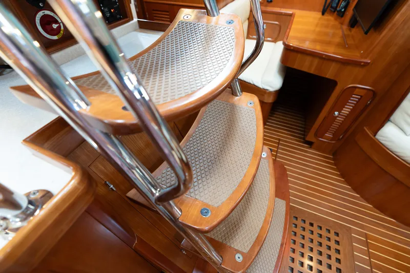 Solitude Yacht Photos Pics Interior of 2018 Passport Vista 545 Center Cockpit with wooden stairs and seating area.