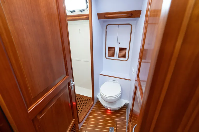 Solitude Yacht Photos Pics 2018 Passport Vista 545 Center Cockpit bathroom with wooden finishes and compact design.