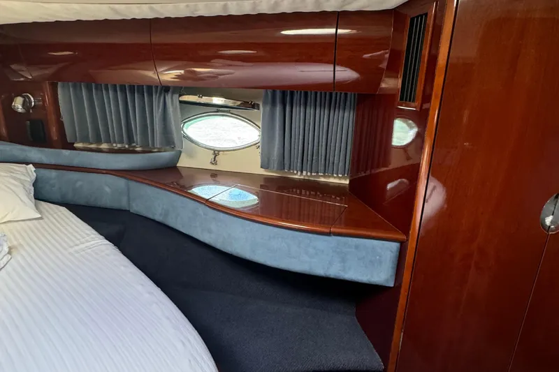  Yacht Photos Pics Luxurious interior of a 2004 Princess V65 yacht with wood finish and porthole window.