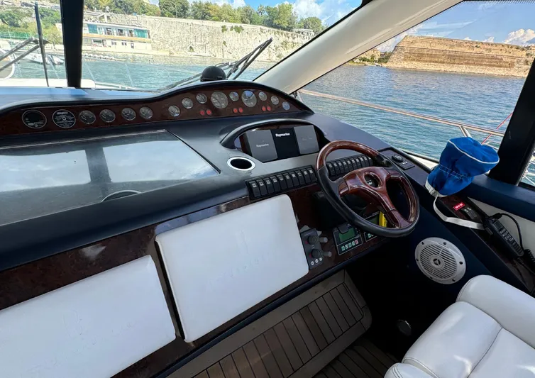 Yacht Photos Pics 2004 Princess V65 yacht helm with steering wheel, controls, and water view.
