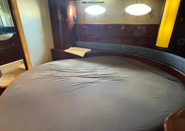  Yacht Photos Pics Luxurious cabin interior of 2004 Princess V65 yacht with cozy bed and porthole windows.