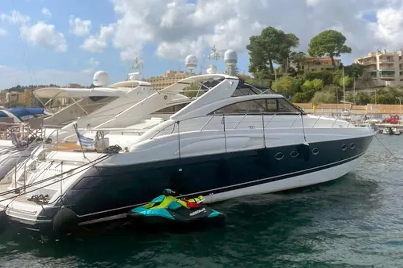  Yacht Photos Pics 2004 Princess V65 yacht docked with jet ski, scenic marina background.