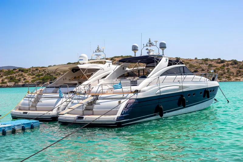  Yacht Photos Pics Two Princess V65 yachts from 2004 anchored in clear turquoise water.