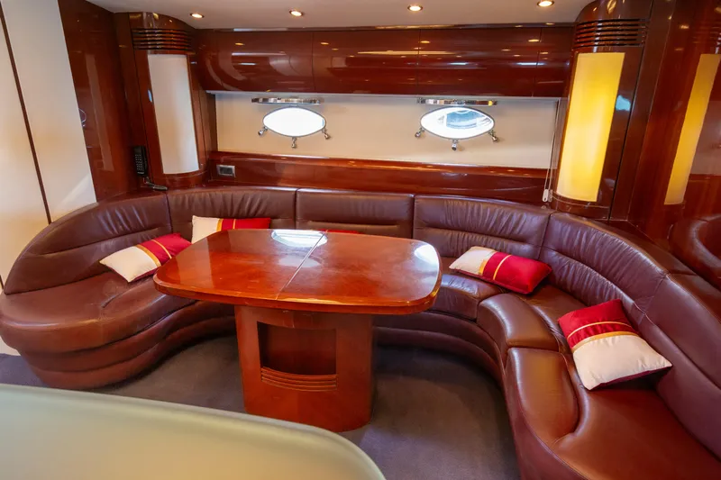  Yacht Photos Pics Luxurious 2004 Princess V65 yacht interior with curved leather seating and elegant wooden table.