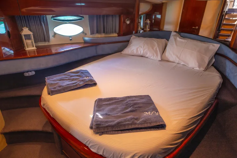 Yacht Photos Pics Luxurious cabin interior of a 2004 Princess V65 yacht with a cozy bed and elegant decor.