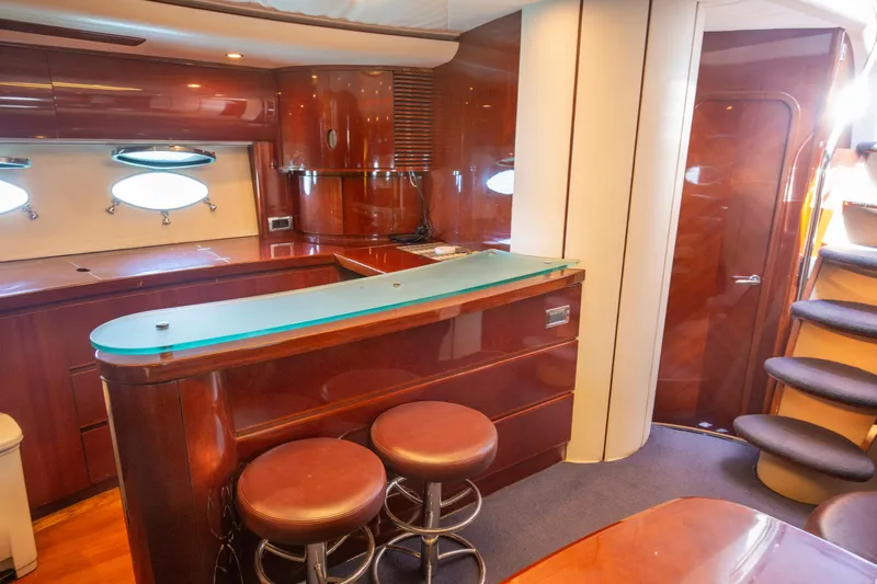  Yacht Photos Pics Luxurious interior of a 2004 Princess V65 yacht with elegant wood finishes and bar seating.