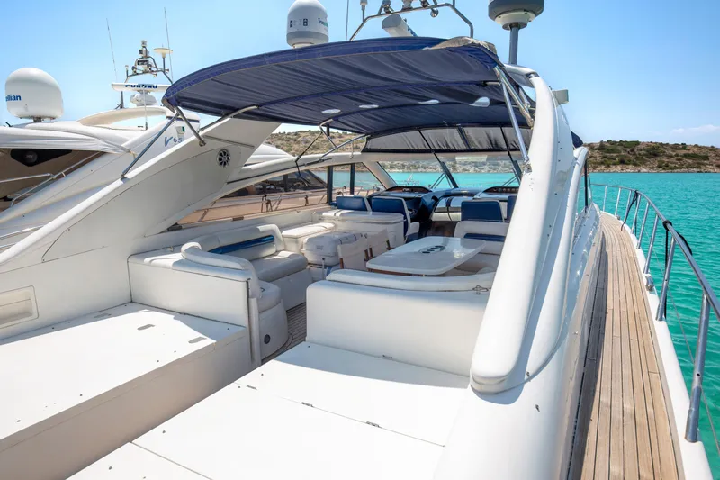  Yacht Photos Pics Luxurious 2004 Princess V65 yacht with spacious deck and seating, docked by turquoise waters.