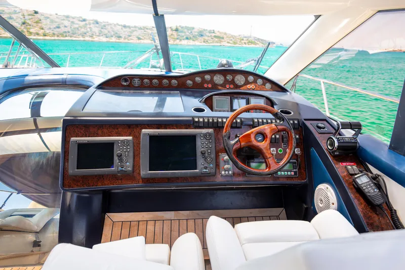  Yacht Photos Pics Luxurious 2004 Princess V65 yacht cockpit with advanced navigation systems and wooden steering wheel.