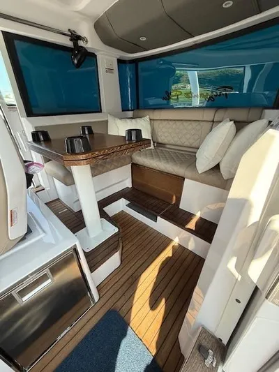  Yacht Photos Pics 2023 Axopar 37 Cross Cabin interior with seating, table, and wood flooring.
