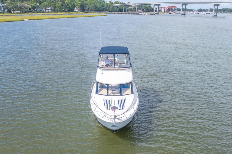  Yacht Photos Pics 2006 Meridian 341 Sedan cruising on a scenic river with a bridge in the background.