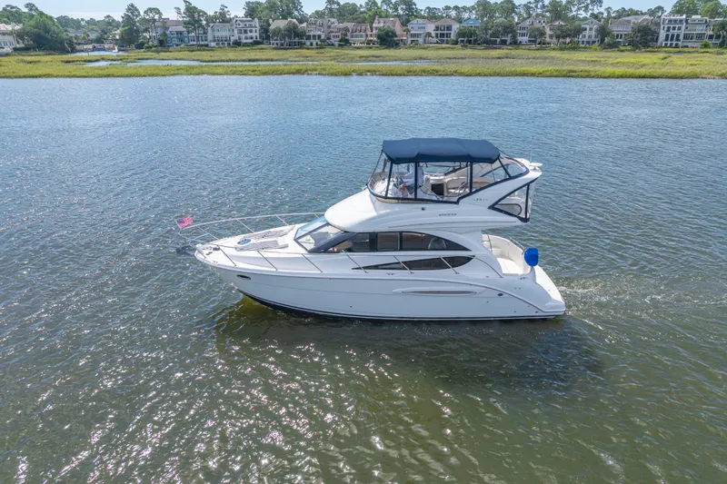  Yacht Photos Pics 2006 Meridian 341 Sedan cruising on a scenic waterway with waterfront homes in the background.