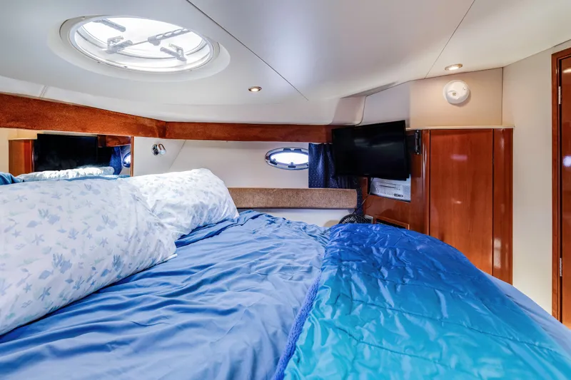 Yacht Photos Pics Luxurious cabin interior of 2006 Meridian 341 Sedan yacht with cozy bedding and porthole.