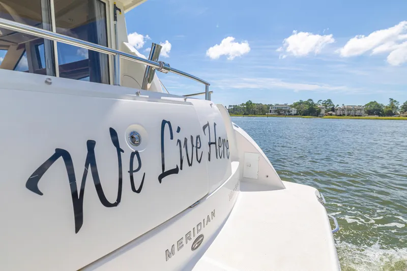  Yacht Photos Pics 2006 Meridian 341 Sedan yacht with "We Live Here" text, cruising on a sunny day.