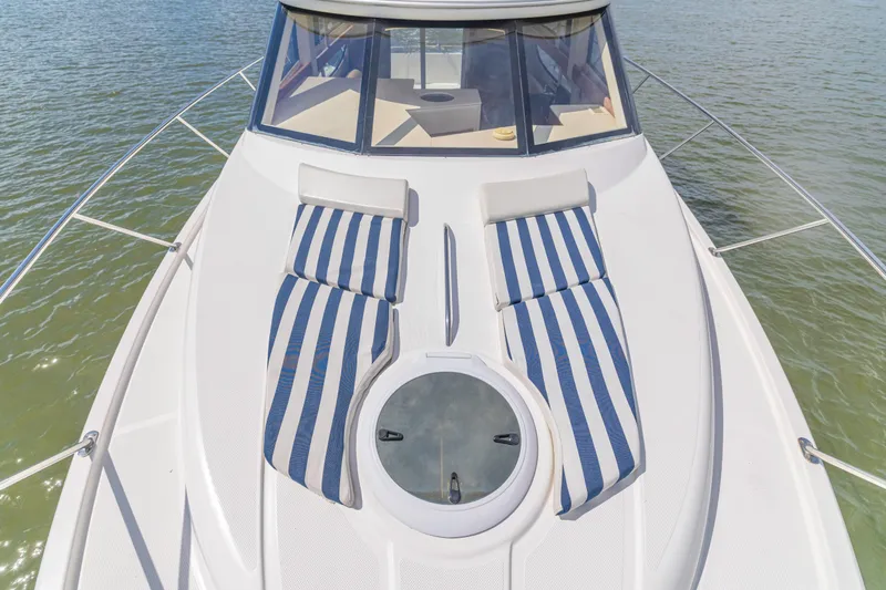  Yacht Photos Pics 2006 Meridian 341 Sedan yacht with striped sun loungers on deck, floating on water.