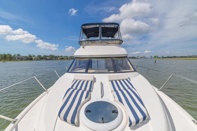  Yacht Photos Pics 2006 Meridian 341 Sedan yacht on water, featuring striped deck cushions under a blue sky.
