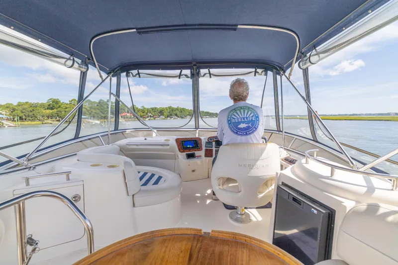  Yacht Photos Pics 2006 Meridian 341 Sedan interior with captain steering on a sunny day.