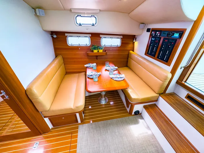 4750fr Yacht Photos Pics 2012 MJM 40z Downeast yacht interior with tan seating and wooden table.