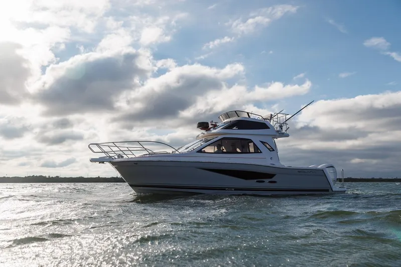  Yacht Photos Pics 2026 Solara S-310 SB boat cruising on open water under a cloudy sky.