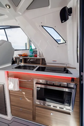  Yacht Photos Pics Modern kitchen area in 2026 Solara S-310 SB boat with sleek appliances and wood cabinetry.