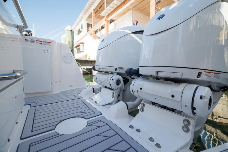  Yacht Photos Pics 2026 Solara S-310 SB boat with dual outboard engines, docked near a waterfront building.