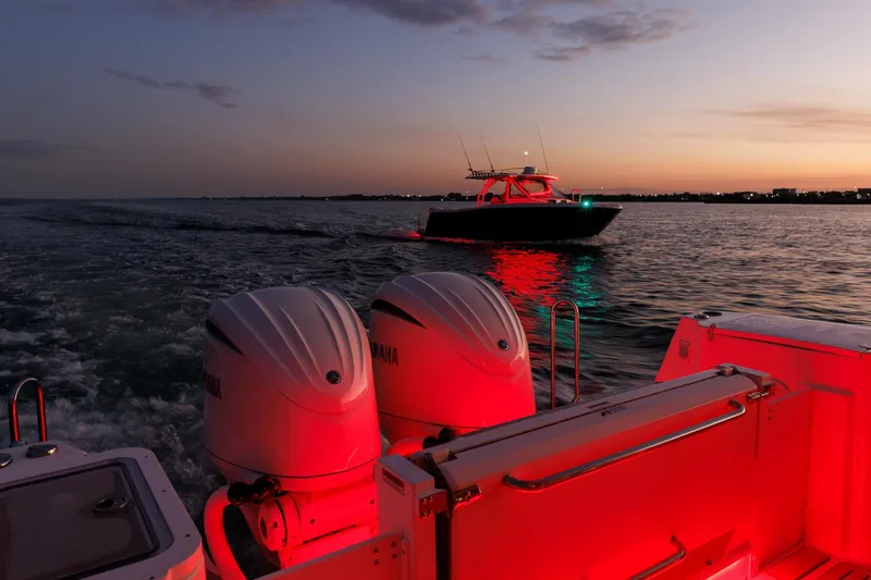  Yacht Photos Pics Sunset view of Solara S-310 SB boat on water, illuminated by red lights.