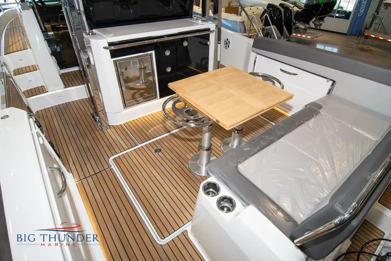 Yacht Photos Pics 2022 Jeanneau Leader 10.5 boat interior with seating, table, and kitchenette.