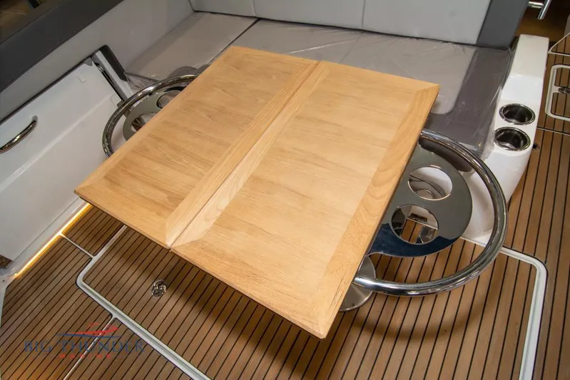  Yacht Photos Pics 2022 Jeanneau Leader 10.5 cockpit with wooden table and seating area.