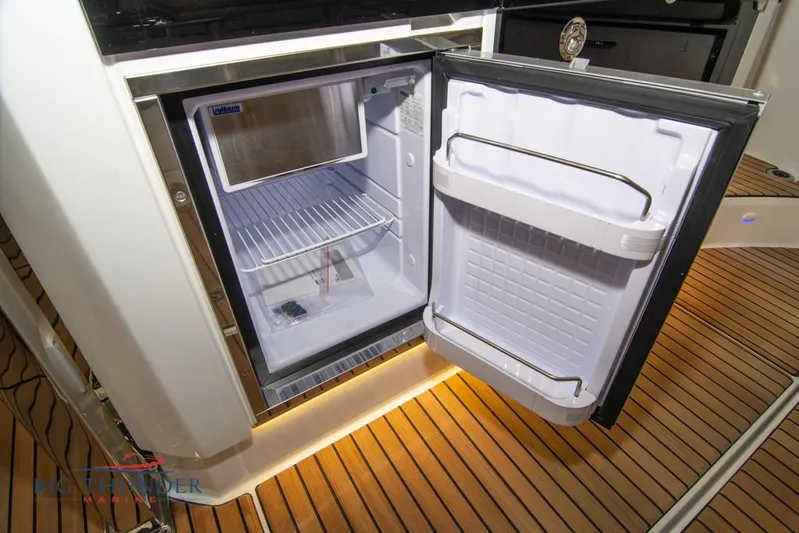  Yacht Photos Pics Open refrigerator on Jeanneau Leader 10.5 boat, showcasing interior storage space, 2022 model.