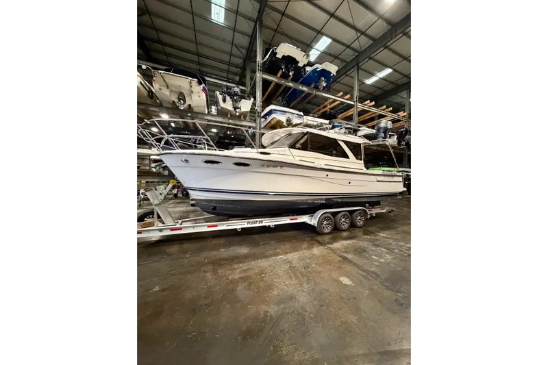  Yacht Photos Pics 2023 Cutwater C-30 Sedan boat on trailer in indoor storage facility.