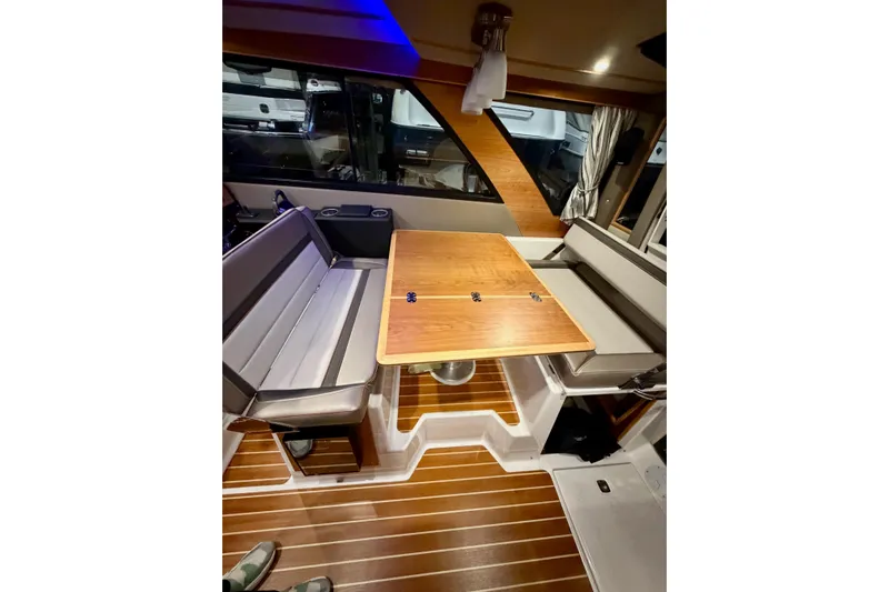  Yacht Photos Pics 2023 Cutwater C-30 Sedan interior with wooden table and cushioned seating.