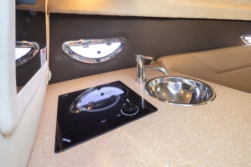 Cobalt Yacht Photos Pics Compact kitchen area in a 2008 Cobalt 303 boat with a sink and stove.