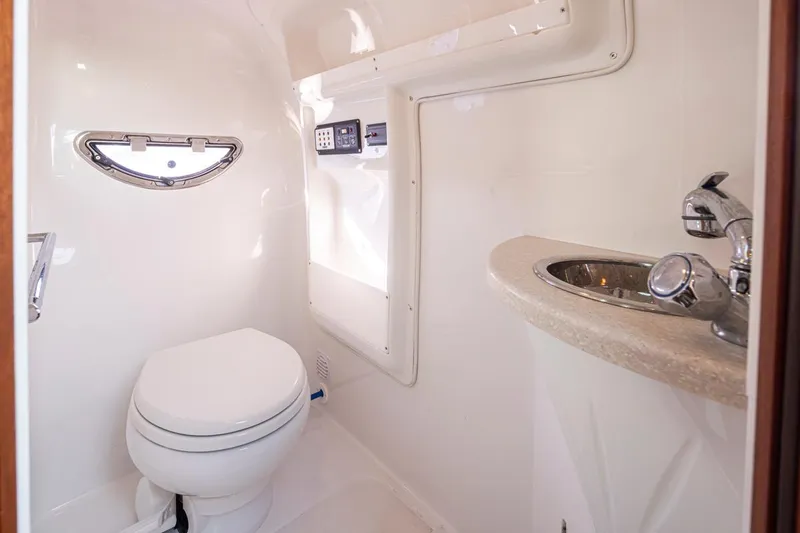 Cobalt Yacht Photos Pics 2008 Cobalt 303 boat bathroom with toilet, sink, and porthole window.