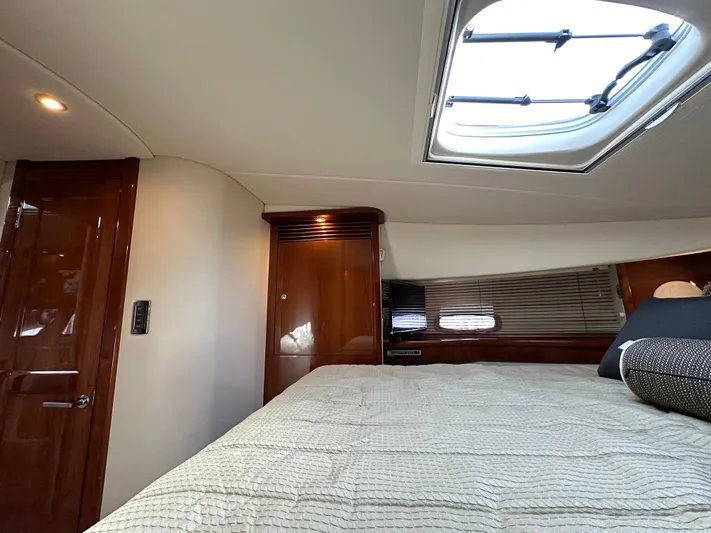  Yacht Photos Pics 2009 Sea Ray 48 Sundancer cabin interior with bed, skylight, and wooden cabinetry.
