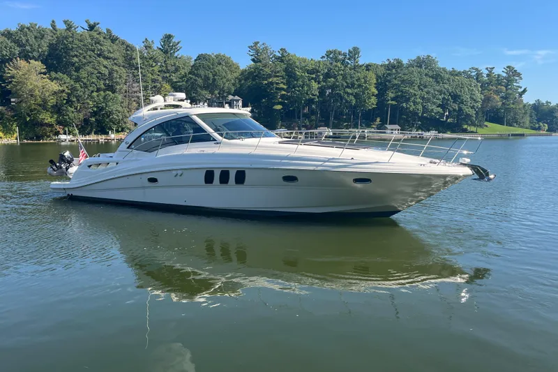  Yacht Photos Pics 2009 Sea Ray 48 Sundancer yacht on a serene lake with lush green trees.