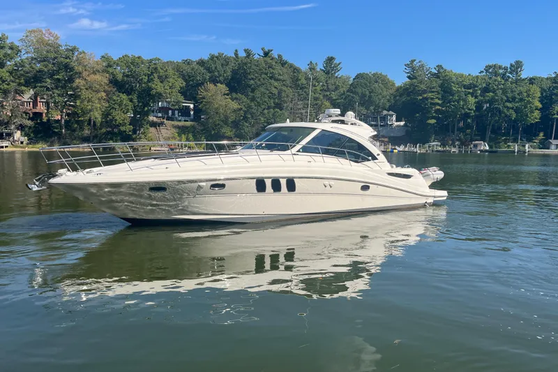  Yacht Photos Pics 2009 Sea Ray 48 Sundancer yacht on a serene lake with lush green surroundings.