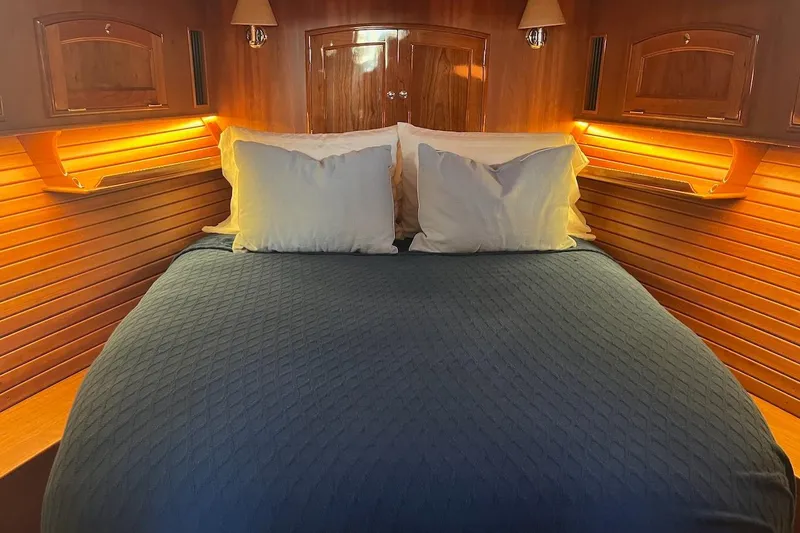 Cassidy Yacht Photos Pics Luxurious cabin interior of 2013 Hinckley Talaria 48 MY with cozy bedding and warm lighting.