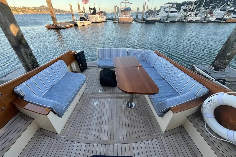 Cassidy Yacht Photos Pics Hinckley Talaria 48 MY 2013 yacht deck with cushioned seating and wooden table.