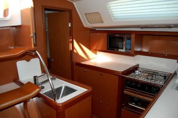 Le Reve Yacht Photos Pics Interior of 2008 Beneteau Oceanis 49 yacht kitchen with wood finish and modern appliances.