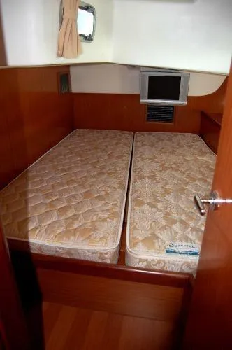 Le Reve Yacht Photos Pics Cabin interior of 2008 Beneteau Oceanis 49 with twin mattresses and wooden finish.