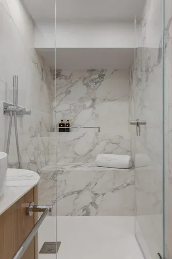 2026 Moon 60 Sail New Yacht Photos Pics Luxurious marble bathroom in Moon 60 Sail yacht, 2026 model, featuring modern shower design.