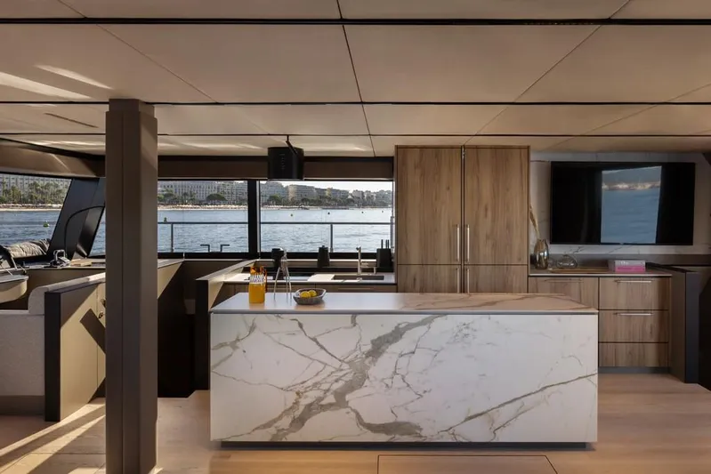 2026 Moon 60 Sail New Yacht Photos Pics Luxurious interior of 2026 Moon 60 Sail yacht with modern kitchen and scenic ocean view.