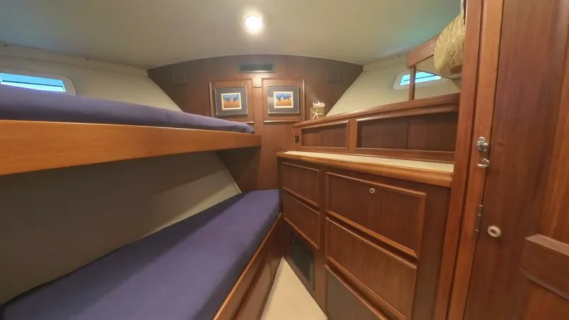 Carry On Yacht Photos Pics 1982 Hatteras 65 LRC cabin with wooden interior and bunk beds.