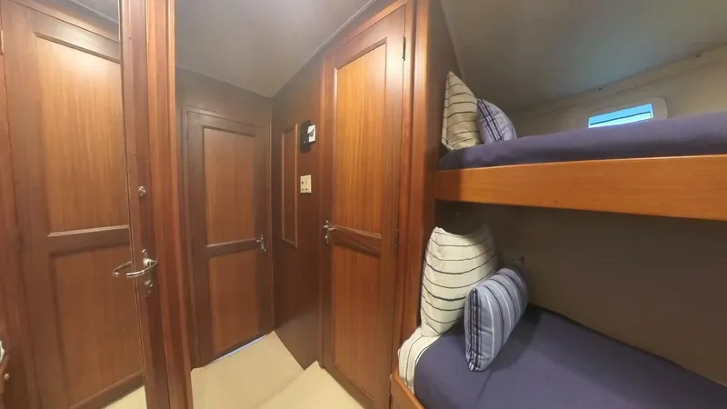 Carry On Yacht Photos Pics Interior of 1982 Hatteras 65 LRC yacht with wooden paneling and bunk beds.