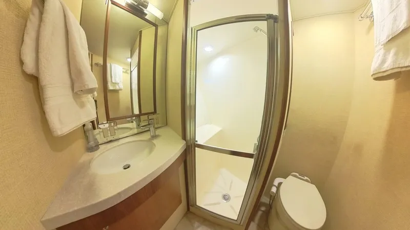 Carry On Yacht Photos Pics Bathroom interior of 1982 Hatteras 65 LRC yacht with shower, sink, and toilet.