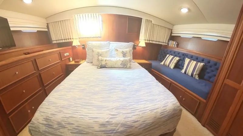 Carry On Yacht Photos Pics Luxurious bedroom interior of 1982 Hatteras 65 LRC yacht with cozy bed and seating area.