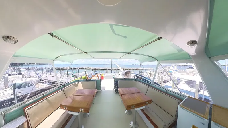 Carry On Yacht Photos Pics Interior view of 1982 Hatteras 65 LRC yacht with seating and tables, docked at marina.