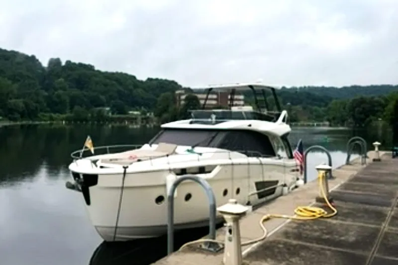 Steel Dreamin Yacht Photos Pics 2022 Greenline 45 Fly yacht docked by a serene lake with lush greenery.