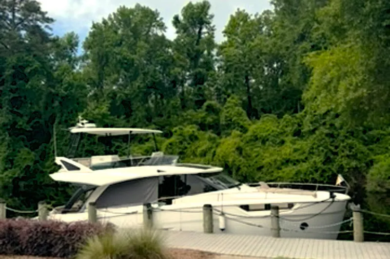 Steel Dreamin Yacht Photos Pics 2022 Greenline 45 Fly yacht with hardtop and solar panels docked by lush greenery.