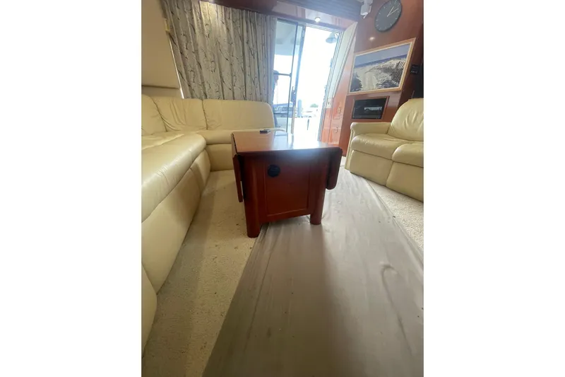 Sea Spirit Yacht Photos Pics Interior of 2004 Carver 570 Voyager Pilothouse with beige leather seating and wooden table.