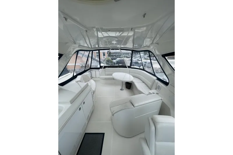 Sea Spirit Yacht Photos Pics Luxurious interior of 2004 Carver 570 Voyager Pilothouse yacht with white seating and panoramic windows.